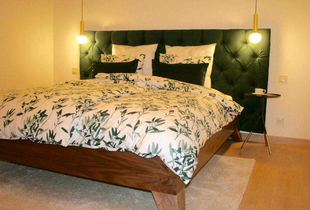 利耶帕亚Elegant apartment的一间卧室配有一张大床和绿色床头板