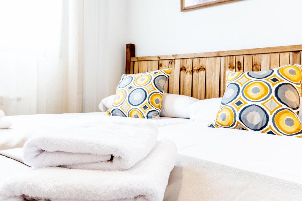 马德里El Chato Madrid的卧室内的两张床和毛巾