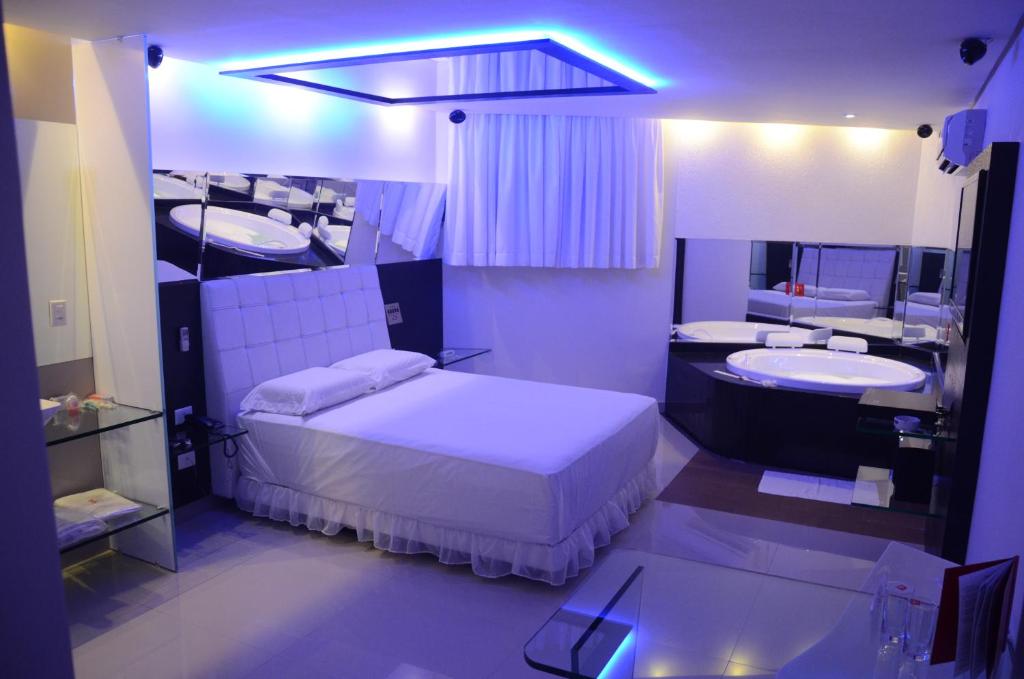累西腓Eros Hotel - Adult Only的一间卧室配有一张床、两个水槽和镜子
