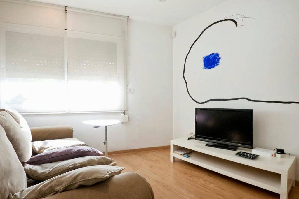 巴塞罗那Apartamento Noemi的客厅配有沙发和桌子上的电视