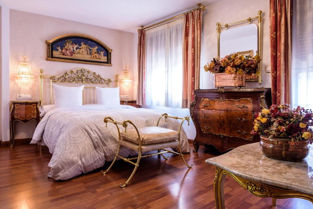 格拉纳达Casa de Reyes的一间卧室配有一张床、一把椅子和一张桌子