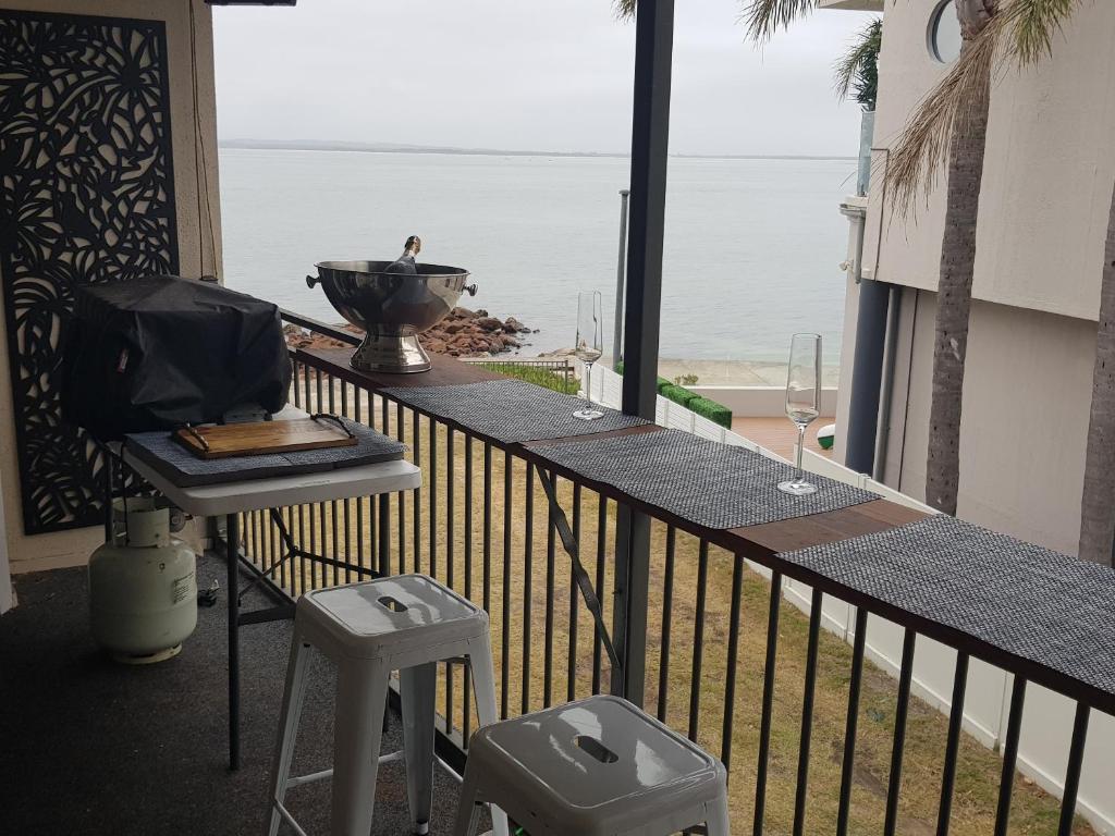 科莱特Waterfront Location - 2 Bed Apartment in Corlette, Port Stephens - Sleeps 4的阳台配有桌子,享有海景。