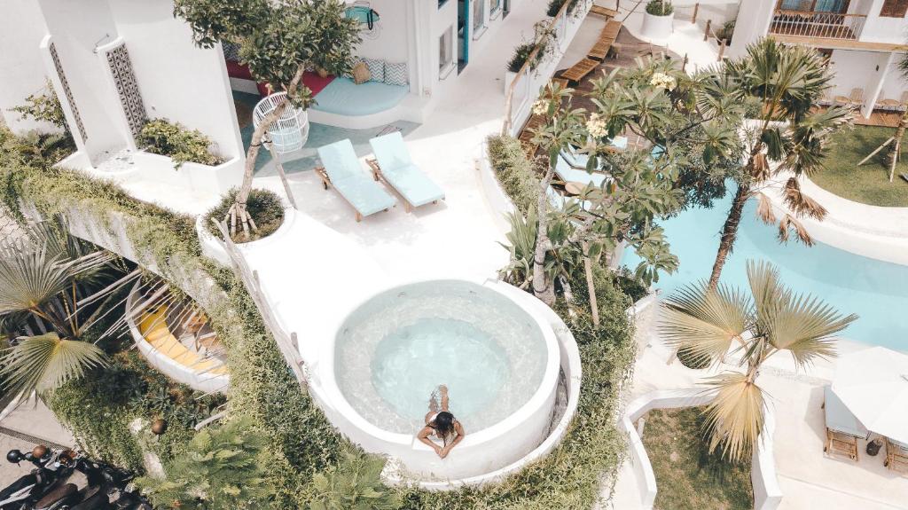 坎古Kos One Hostel的棕榈树泳池中一个人的头顶景色