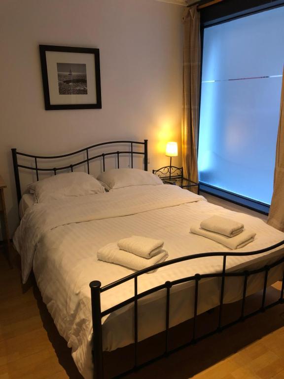 布鲁塞尔阿伯丁酒店的一间卧室配有一张大床和两条毛巾