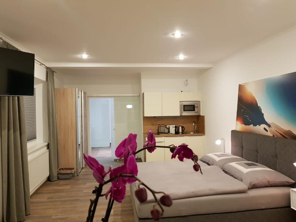 圣吉尔根Echt Heimat Apartments的客厅配有沙发和粉红色的鲜花