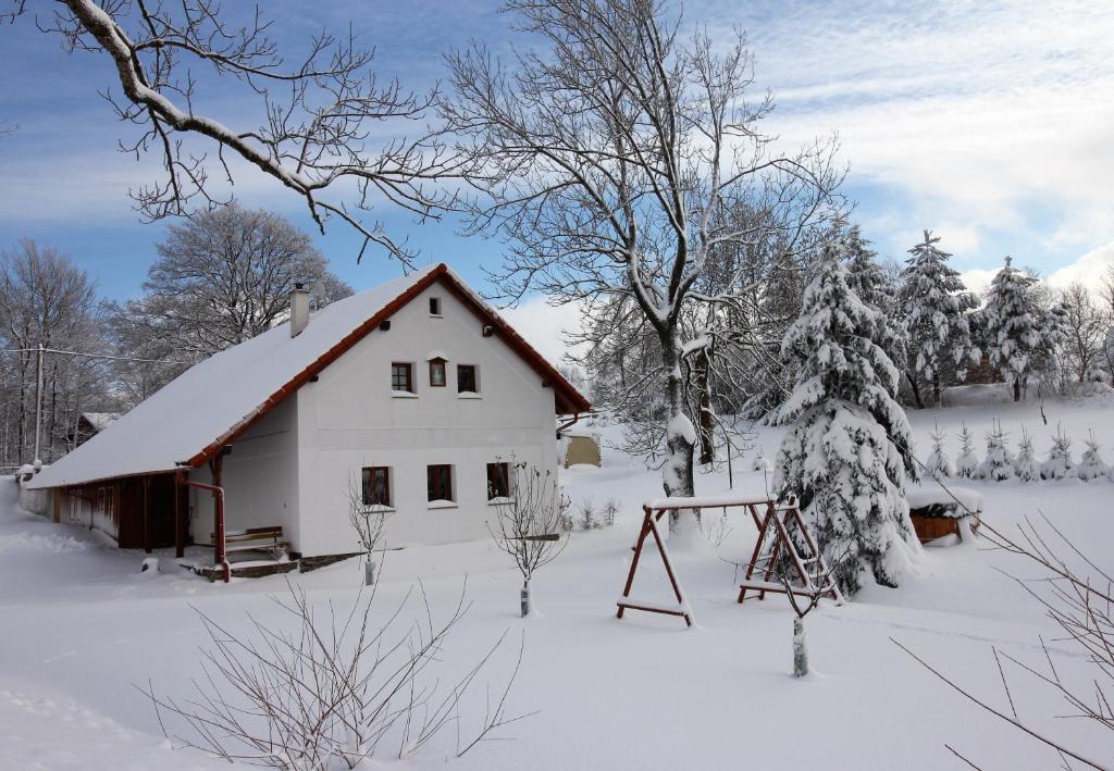 PetroviceApartmány u Knajflů的雪地中的白色谷仓,带秋千