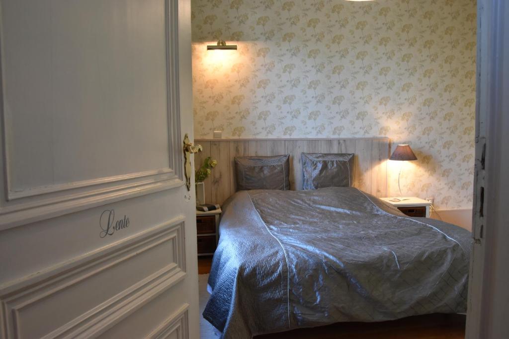 博尔赫隆赫特兰德霍夫住宿加早餐旅馆的一间卧室配有一张带蓝色棉被的床