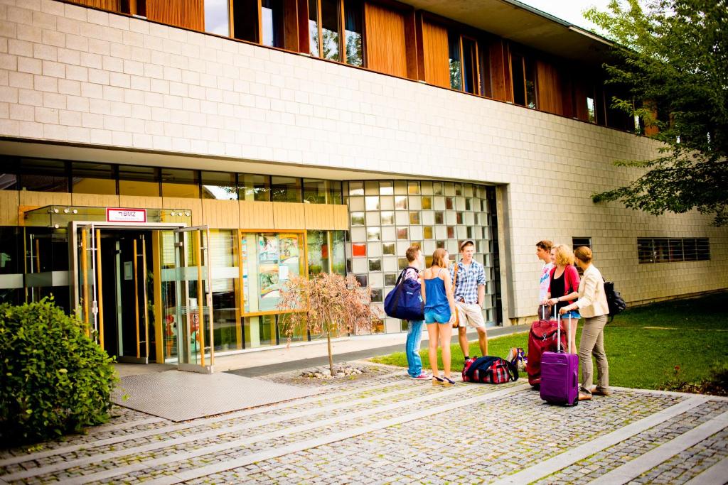 达豪达豪国际青年旅馆的一群人站在大楼外,带着行李