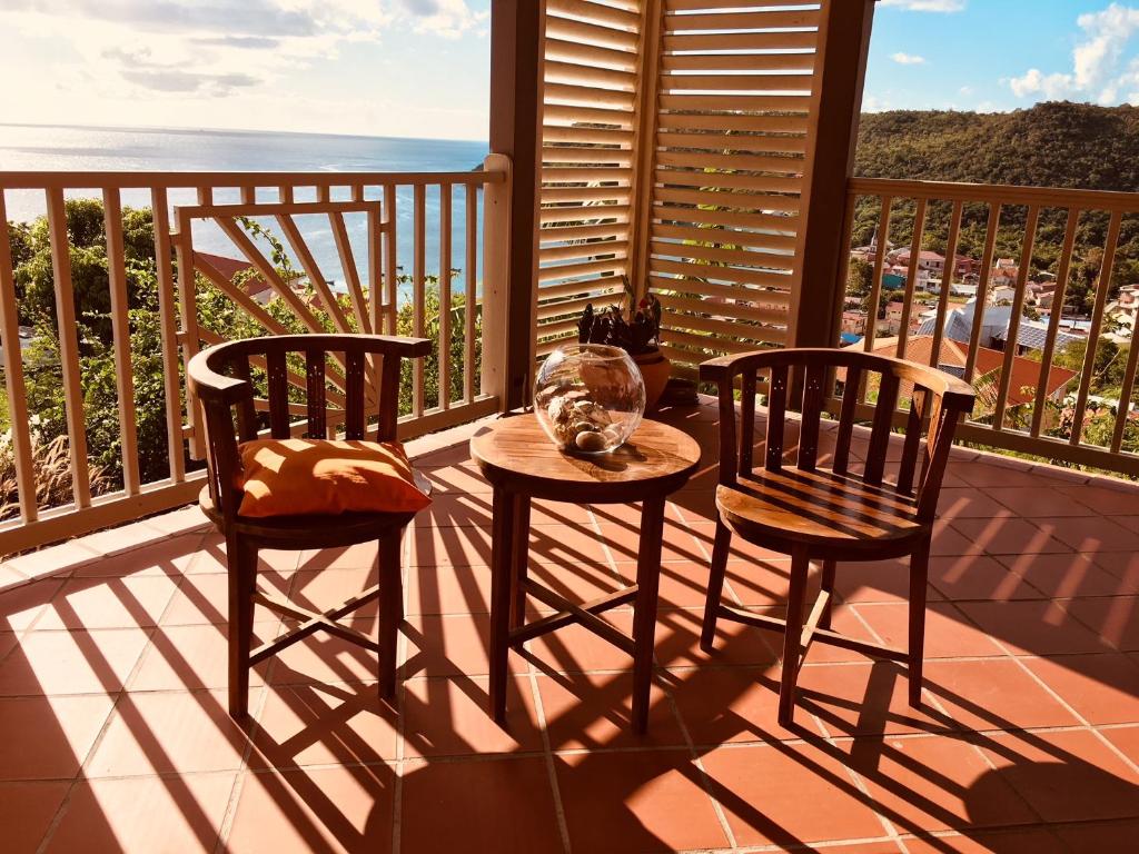 莱昂斯-达赫雷La Villa Kanel的阳台配有一张桌子和两把椅子,享有海景