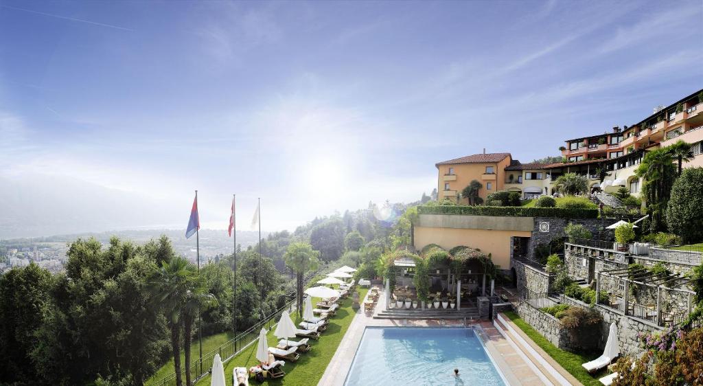 洛迦诺Villa Orselina - Small Luxury Hotel的路边建筑物边的游泳池