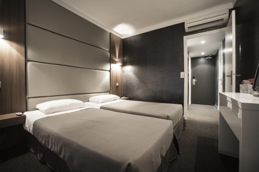 戛纳科罗纳酒店的酒店客房设有两张床和盥洗盆
