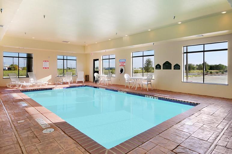 新布朗费尔斯布劳恩费尔斯温盖特温德姆酒店的大型客房的大型游泳池,配有桌椅