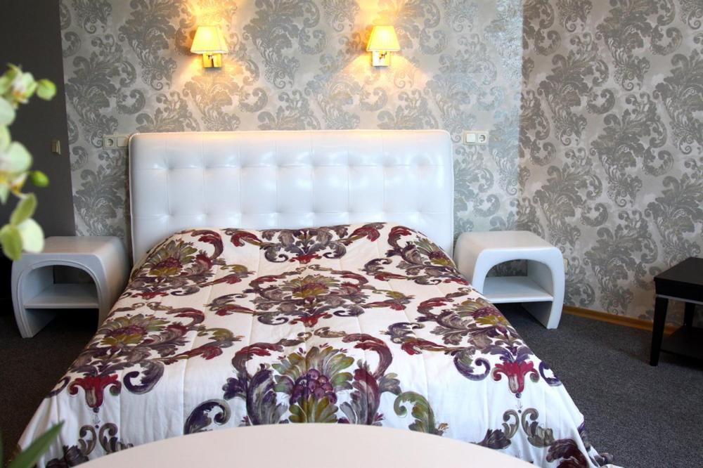 里加费利西亚酒店的卧室配有白色床和鲜花毯子