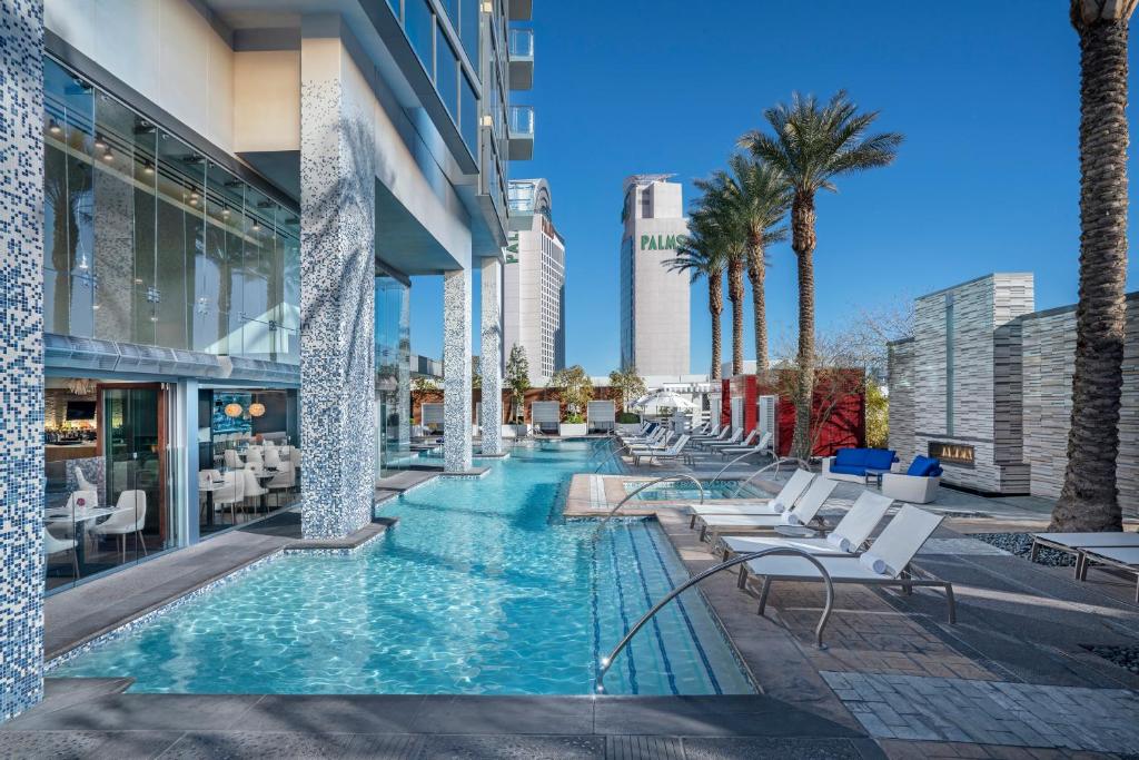 拉斯维加斯Palms Place Hotel and Spa的一座带椅子和棕榈树的游泳池
