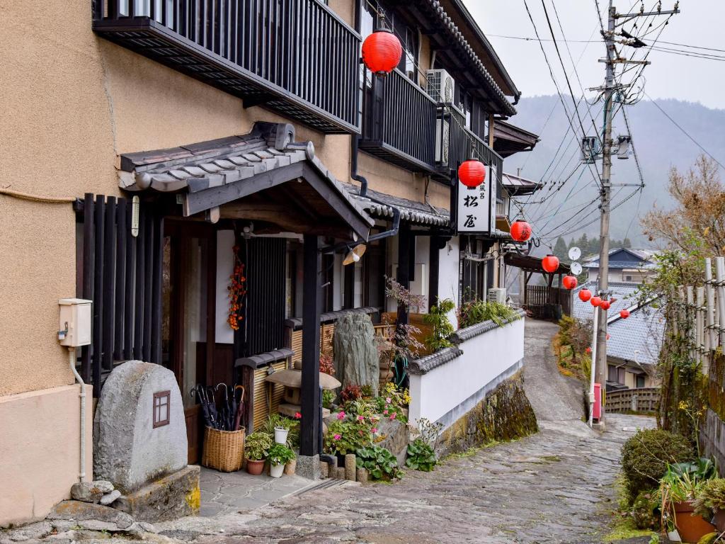 由布市Sanso Matsuya的街道边有红色灯笼的建筑