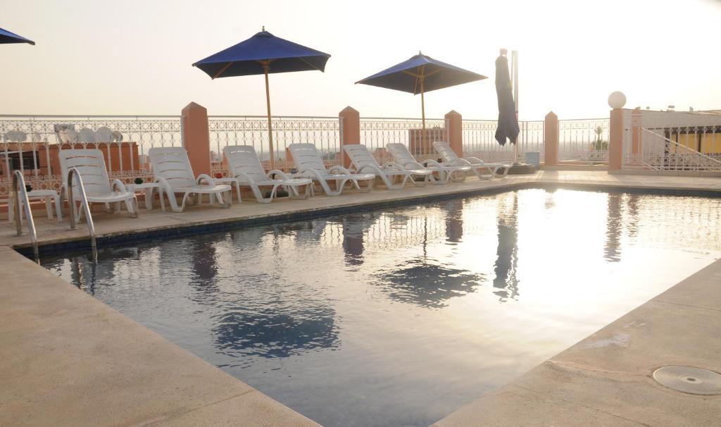 马拉喀什拉辛酒店的一个带躺椅和遮阳伞的游泳池