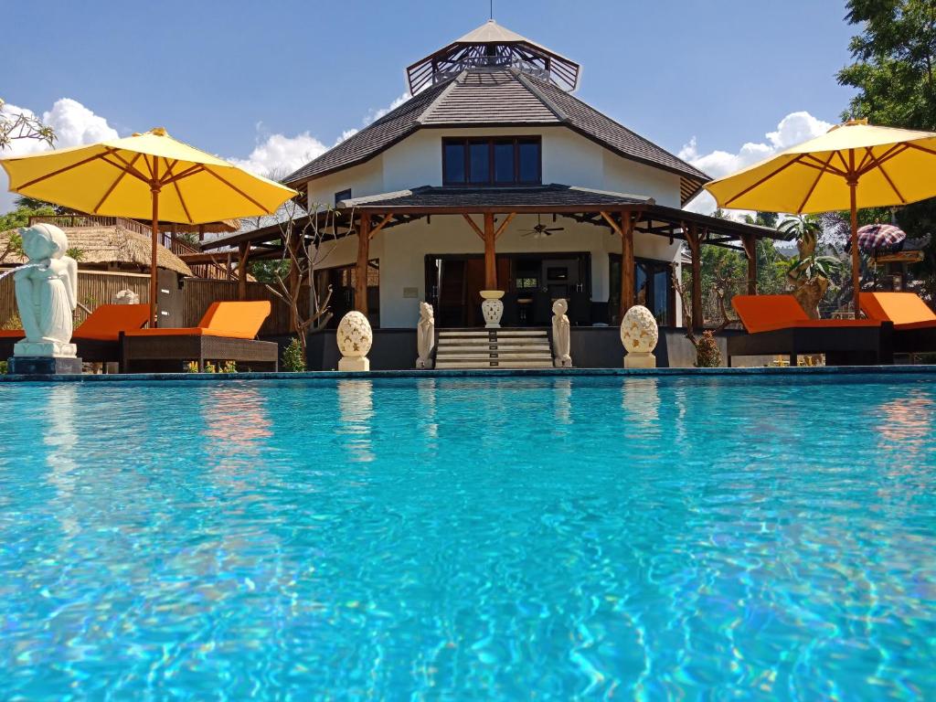 布莱伦Samari Hill Villa的一座房子,设有一座带椅子和遮阳伞的游泳池