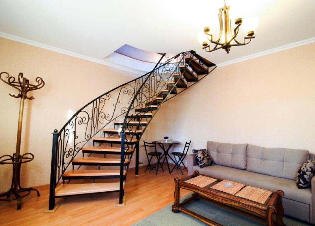 第比利斯ApartHotel Heart of Tbilisi的带沙发的客厅内的螺旋楼梯