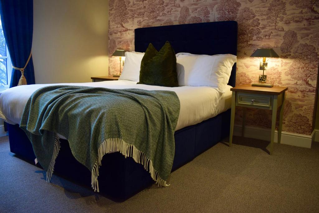 达灵顿The Devonport的一间卧室配有一张大床和蓝色床头板