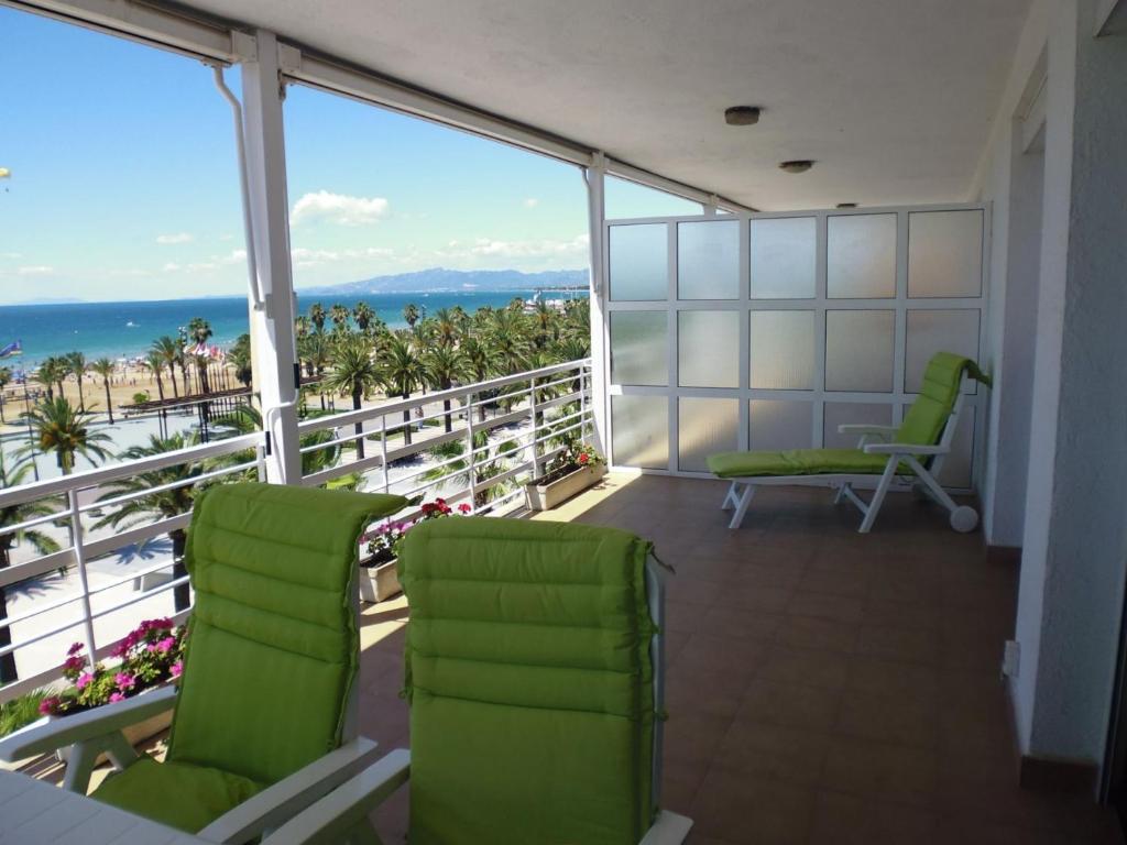 萨洛Zeus Alexis Frontal的阳台设有绿色椅子,享有海景。