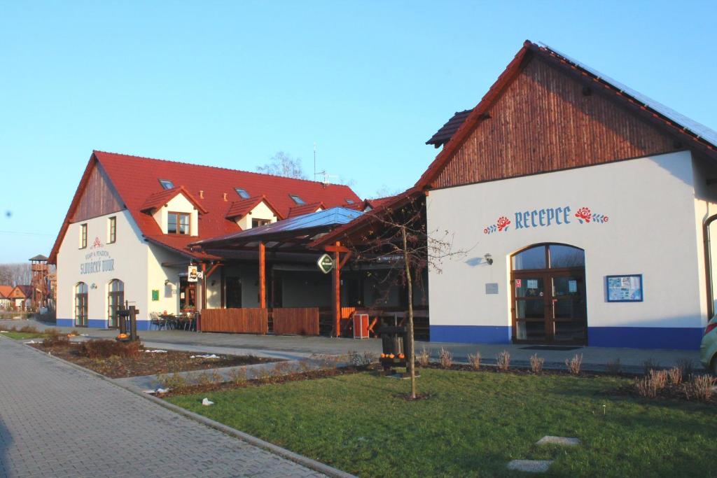 奥斯特罗赫新村Slovácký dvůr s.r.o.的一座白色的大建筑,有红色的屋顶