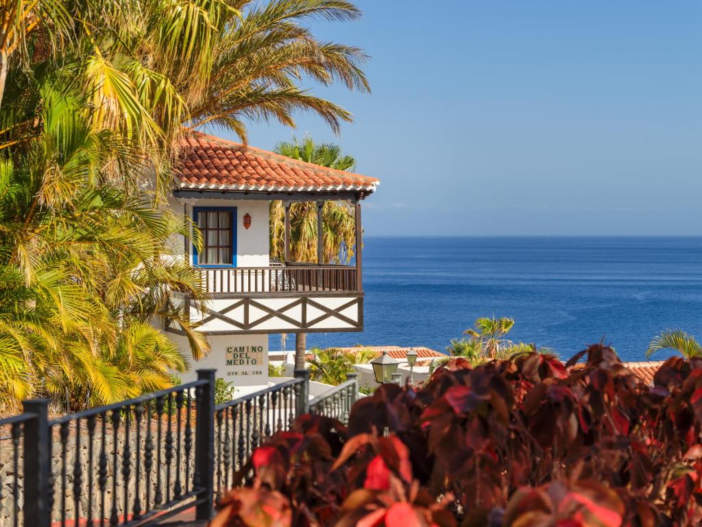 圣地亚哥海滩特辛纳花园酒店的海滩上的房子,背景是大海