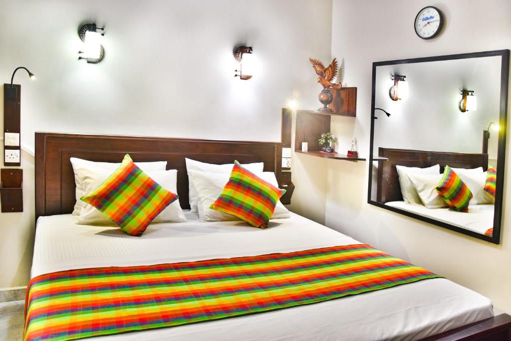 希克杜沃Villa Hikka 08的一间卧室配有一张带彩色条纹枕头的床