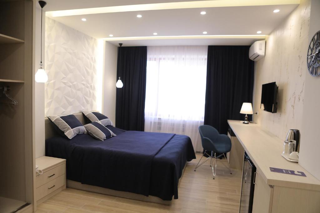 埃里温4Room Hotel的一间卧室配有一张床、一张书桌和一个窗户。