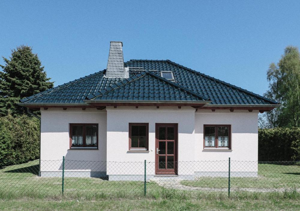 KröslinHaus am Meer的一间黑色屋顶的白色小房子