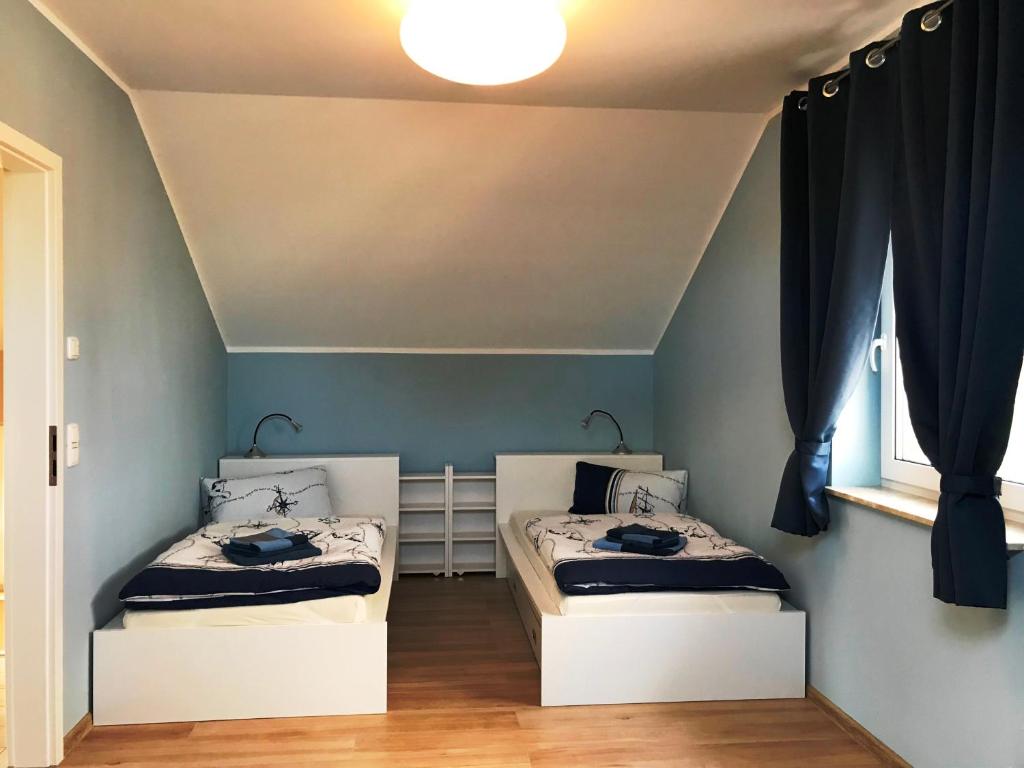 BodstedtHaus Kranichweide的蓝色墙壁客房的两张床