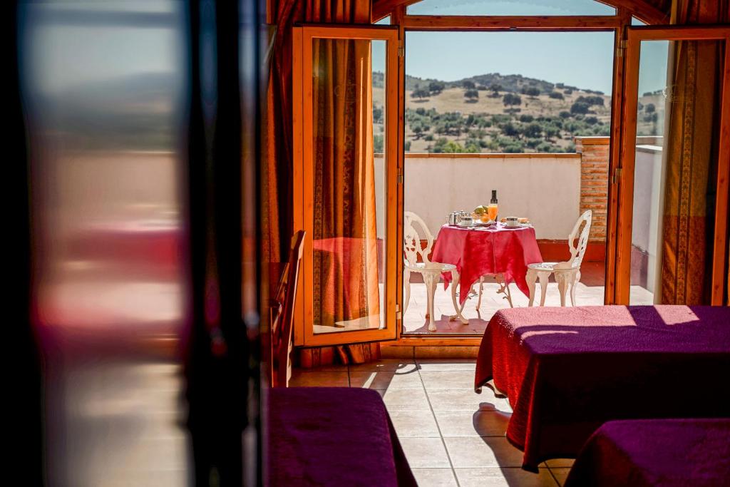圣埃伦娜阿尔夫恩索八世酒店的阳台的用餐室配有桌椅