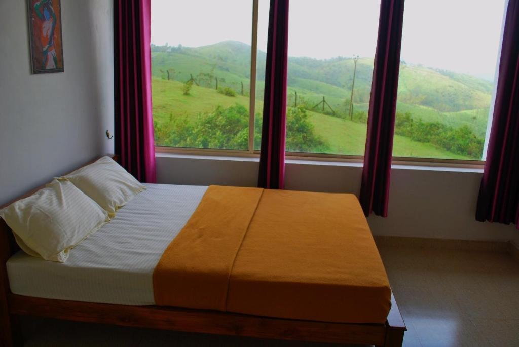 瓦加蒙Vagamon Clouds的一间卧室设有一张床和一个美景窗户。