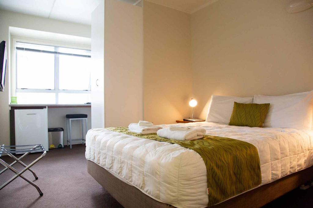 奥克兰City Lodge Accommodation的一间卧室配有带毛巾的床