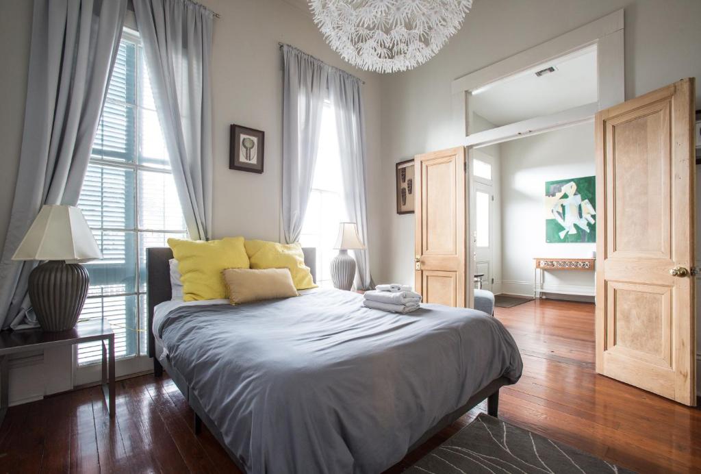 新奥尔良Creole Cottage Uptown的一间卧室配有一张带黄色枕头和吊灯的床。