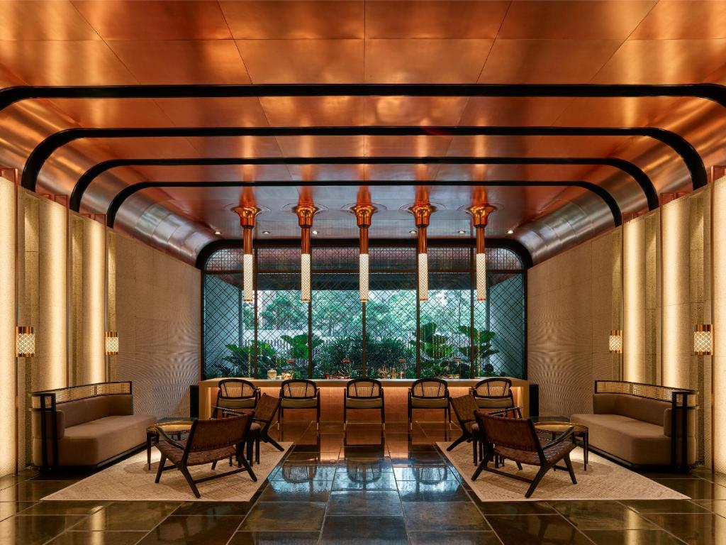 吉隆坡如玛酒店的大堂设有桌椅和大窗户