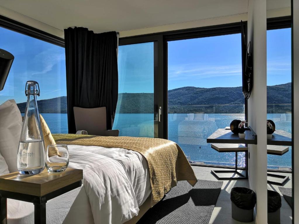 玛里纳Sky Beach Aparthotel的一间卧室设有一张床和一个大型玻璃窗