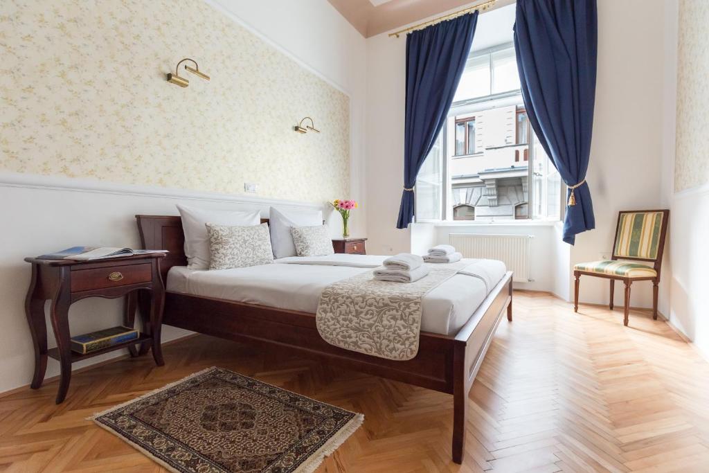 卢布尔雅那Barbo Palace Apartments and Rooms的一间卧室配有一张床、一张桌子和一个窗户。