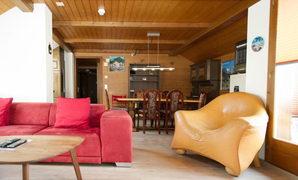 因特拉肯罗斯利假日公寓的客厅配有红色的沙发和桌子
