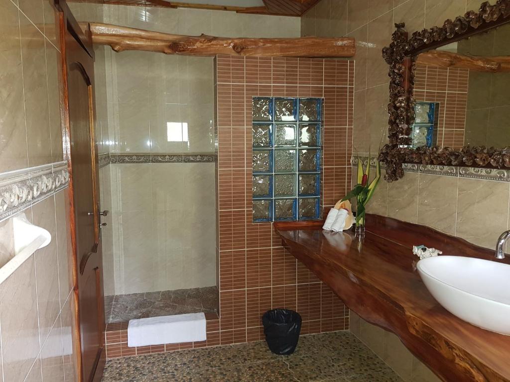 拉迪格岛Elje Villa的浴室配有盥洗盆和带镜子的淋浴