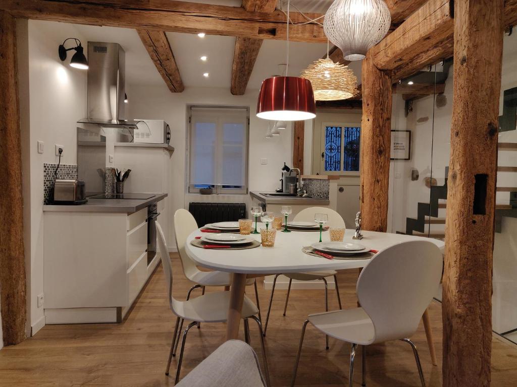 埃圭斯海姆Elsass Design Hygge的厨房以及带白色桌椅的用餐室。
