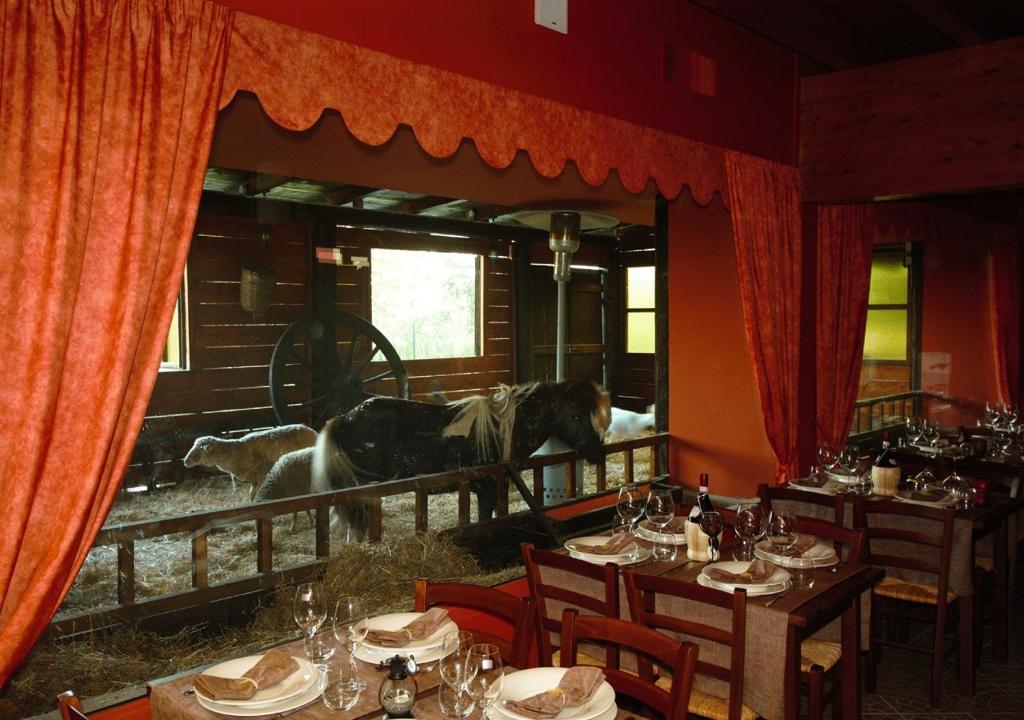Motta deʼConti穆利尼奥桥特纳塔酒店的一间马匹立在窗户上的用餐室