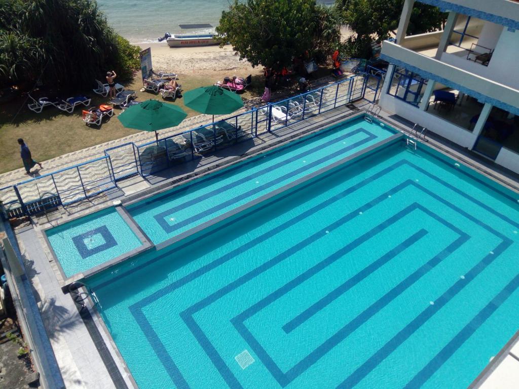 米瑞莎Paradise Beach Resort & Diving school的海滩旁游泳池的顶部景色