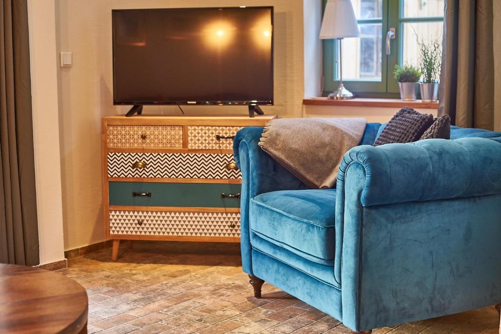 奎德林堡塞勒公寓的客厅配有蓝椅和电视
