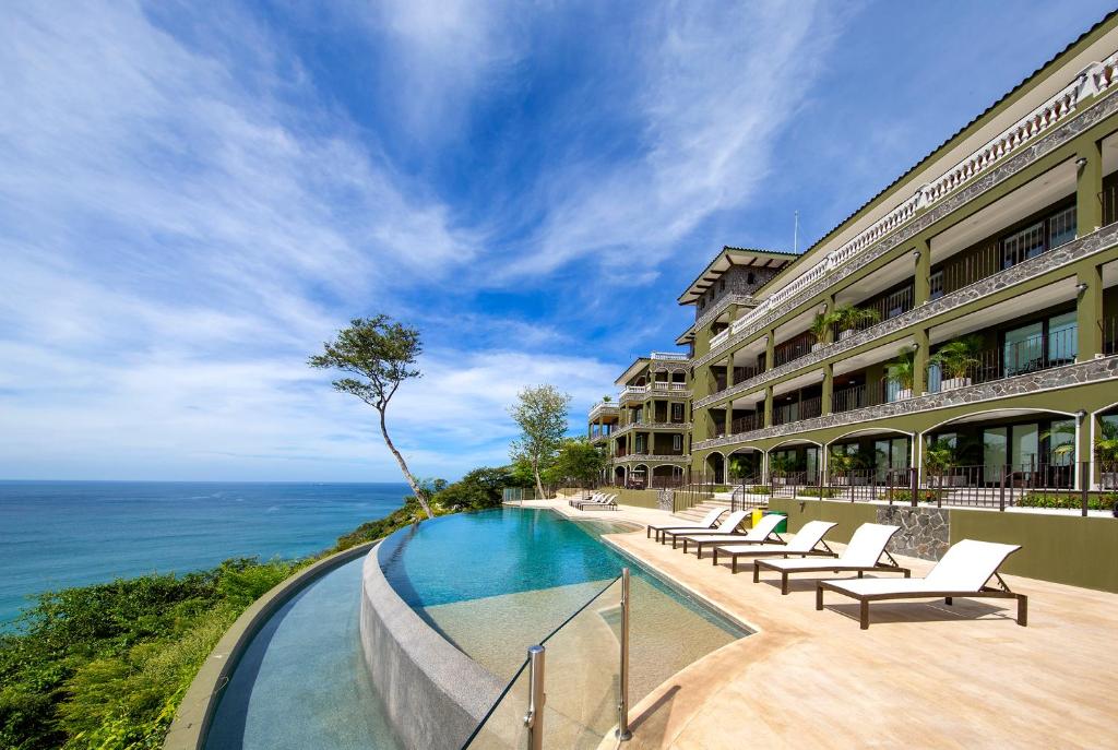 普拉亚弗拉明戈360 Splendor Del Pacifico Residences的一座带游泳池和海洋的酒店