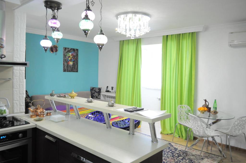 巴库Baku Seafront Apartment的厨房配有白色的柜台和绿色的窗帘