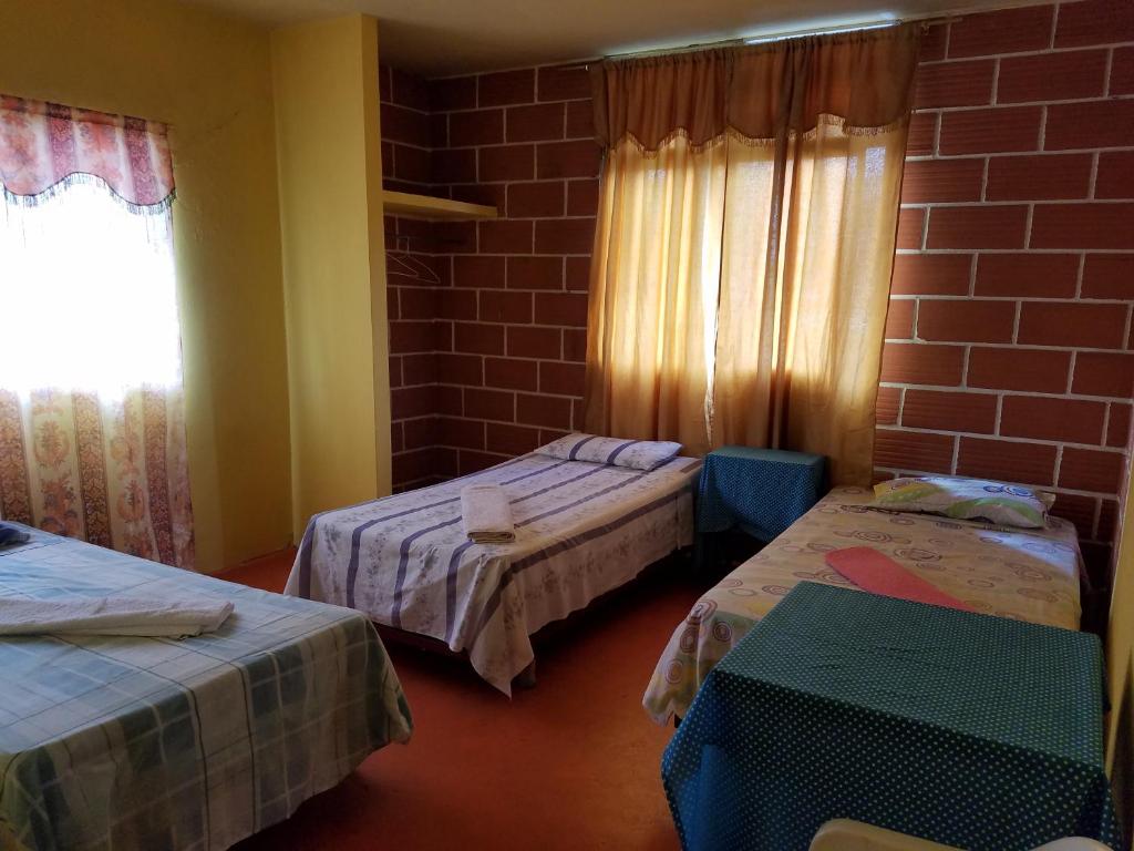 巴克里索莫雷诺港Casa de Alexis的一间设有两张床和砖墙的房间