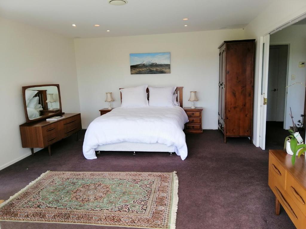 旺格努伊Shurinji的卧室配有一张白色大床和镜子