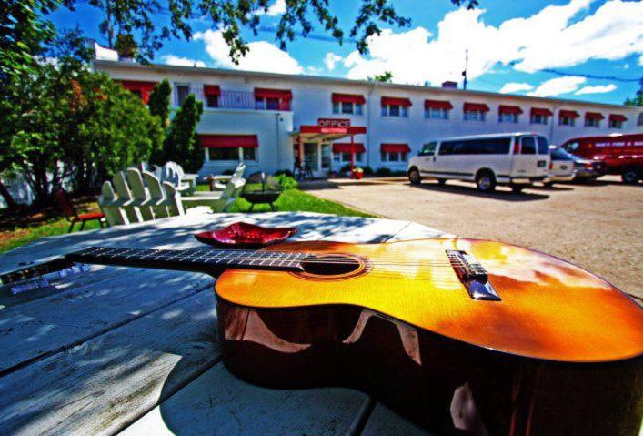 斯特金贝Holiday Music Motel的坐在大楼前桌子上的吉他