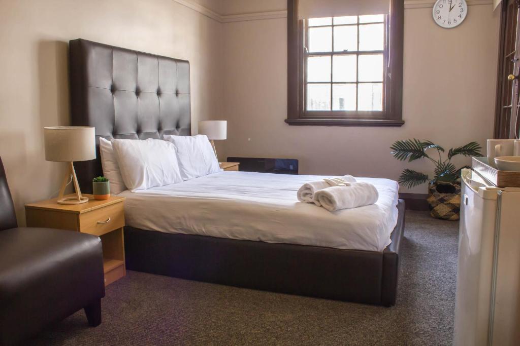 悉尼垦陪思酒店的一间卧室配有一张大床和毛巾