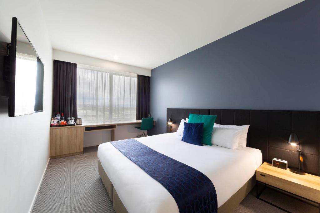 堪培拉曼特拉麦克阿瑟酒店的一间设有大床和窗户的酒店客房
